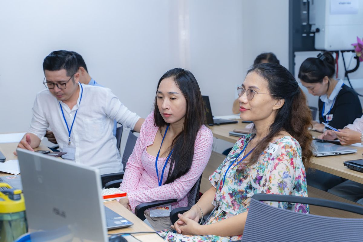 Ba học viên chăm chú nhìn màn hình laptop