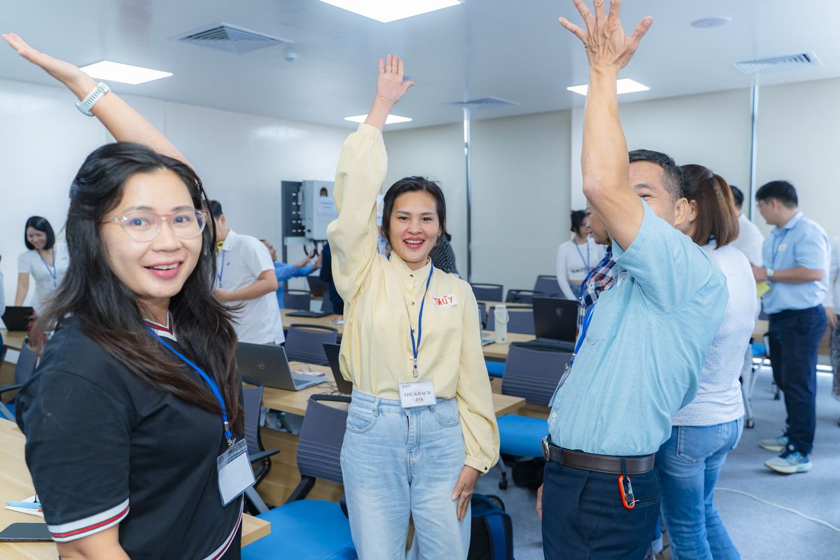 Học viên đứng giơ tay hào hứng trong phần khởi động lớp học